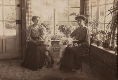 André et Paul Brasseur avec leur mère (à gauche), dans la véranda de la même maison, vers 1918